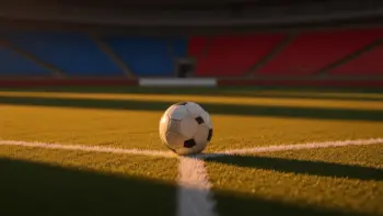 Floodlit football pitch at dusk with match ball on centre spot, golden stadium lighting casting sharp shadows across the turf.