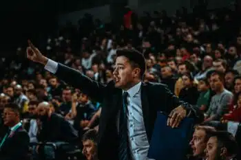 Basketball coach directing his team in a crowded arena