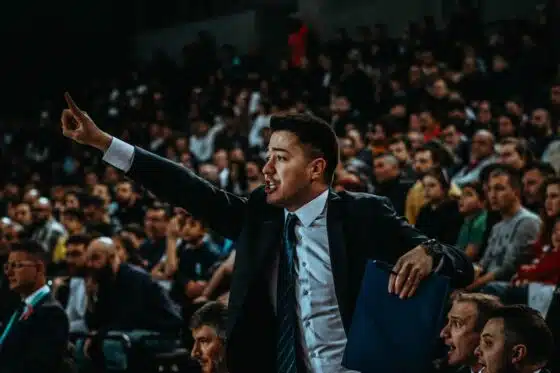Basketball coach directing his team in a crowded arena